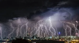 Lightning storm over a city skyline at night, illustrating a broadcast storm stopped by network switch broadcast filtering.