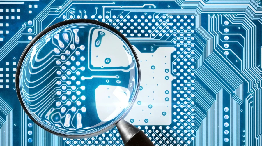 Magnifying glass inspecting a glowing blue circuit board to illustrate SD-WAN edge intelligence and deep packet visibility.