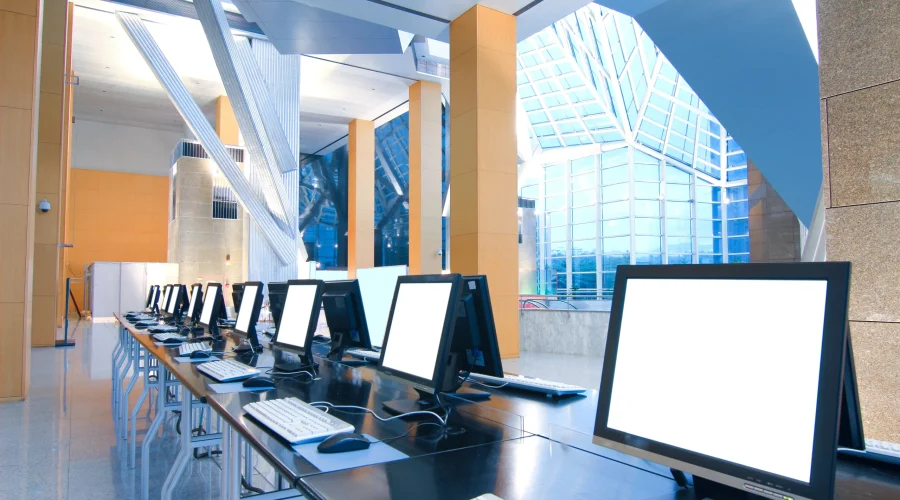 Bright modern school computer lab with rows of desktop monitors powered by reliable SD-WAN for schools.